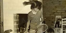 Nina playing air guitar on badmitten racket as a kid